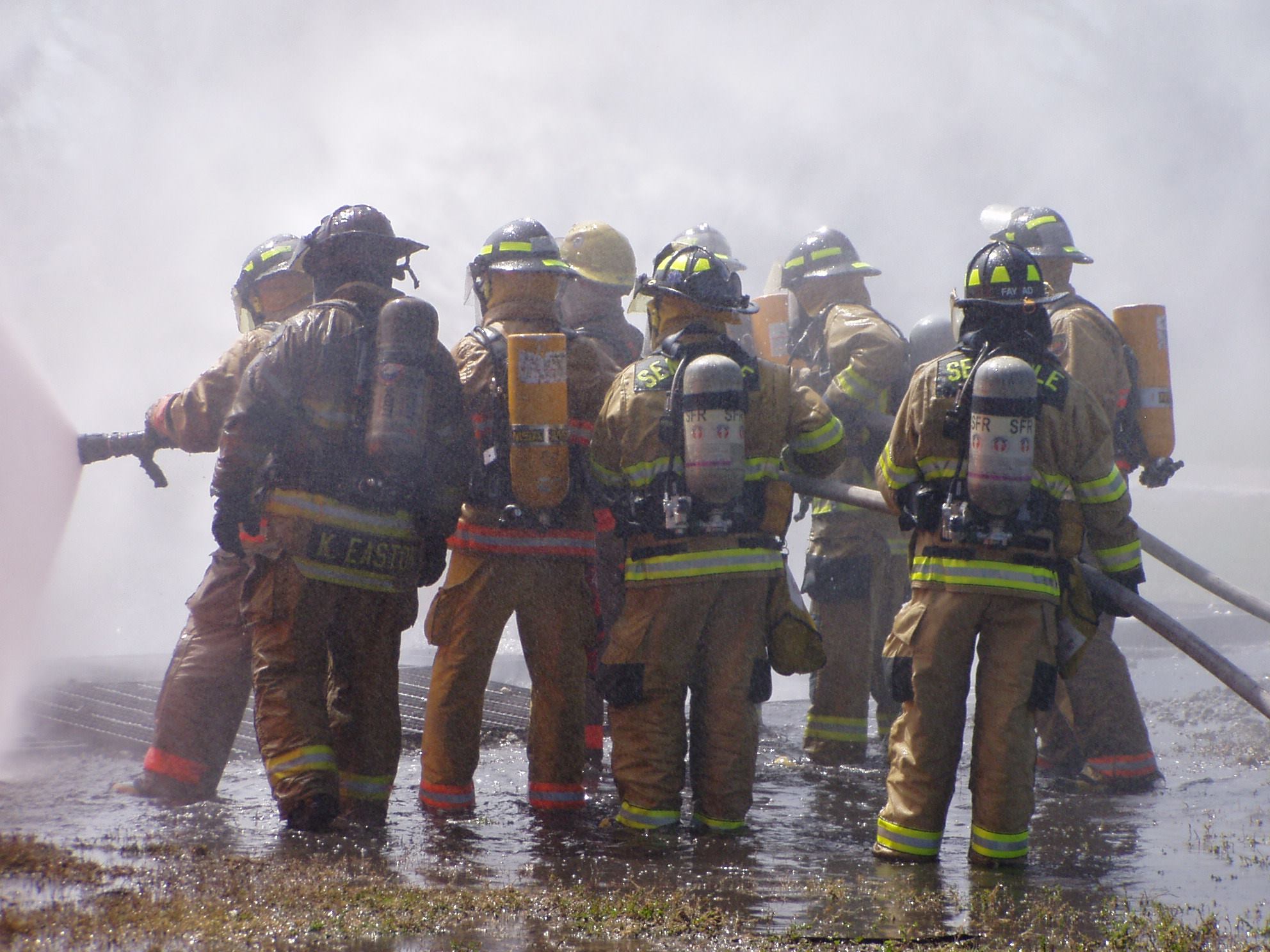 Back of firefighters with hoses