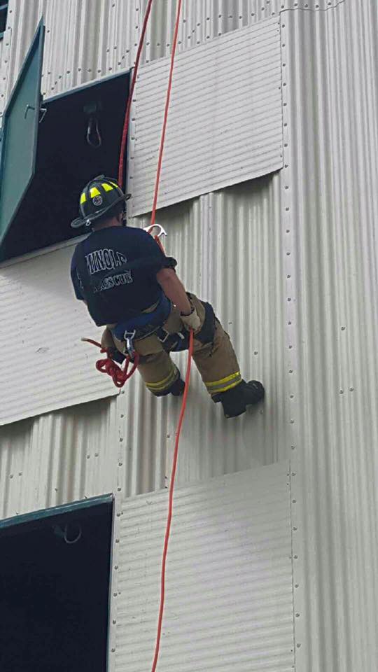 Firefighter rappelling from a building